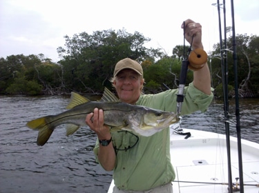 Anglers displaying a snook on a guided fishing trip